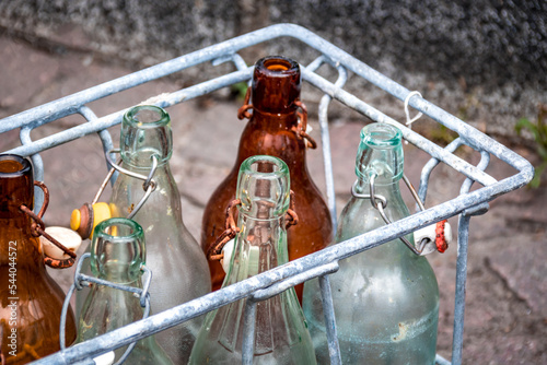 Anciennes bouteille en verre dans un panier en fer photo