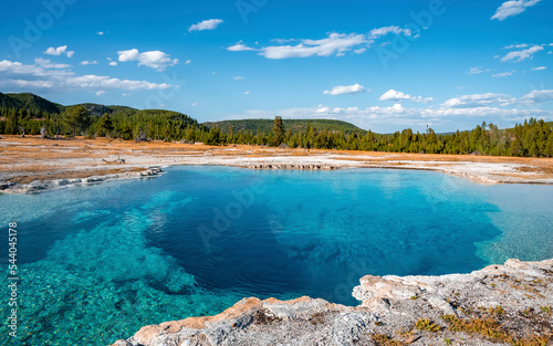 Scenic view of Sapphire Pool with sky in background. Beautiful blue geyser basin at Yellowstone National park. Famous tourist attraction during sunny day.