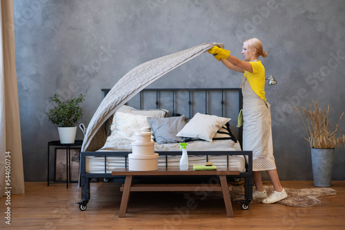 Professional cleaning of the bedroom. maid making the bed. Housekeeping service photo