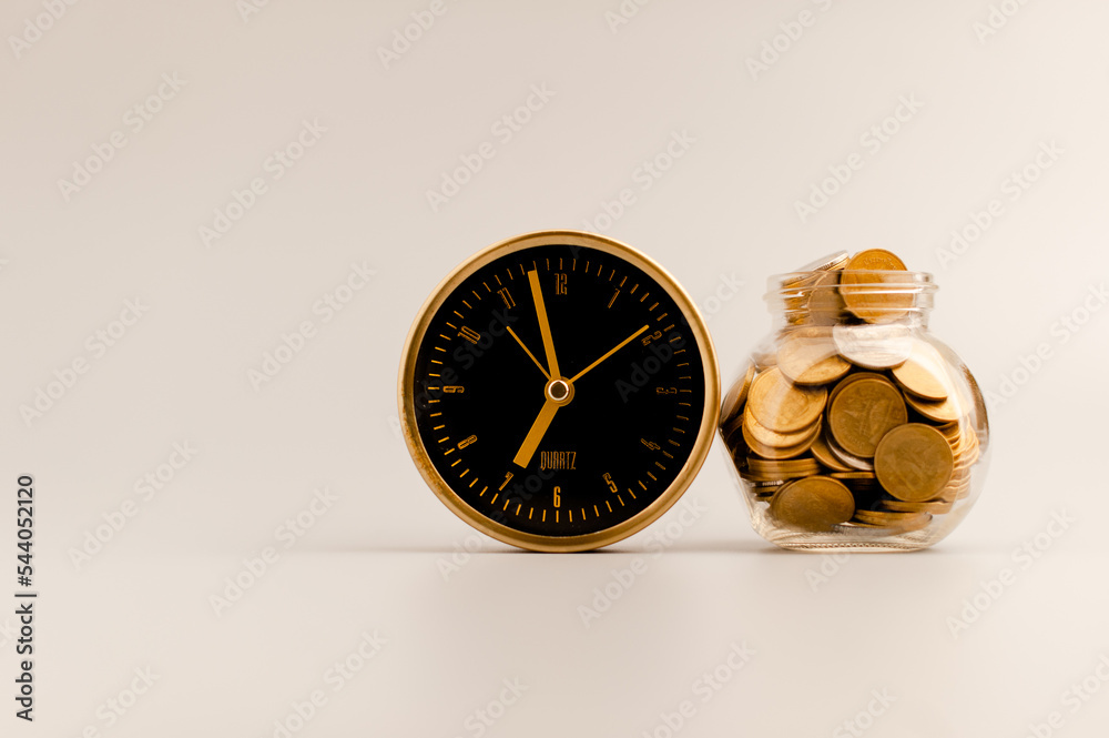 Golden alarm clock and coin in glass bottle, money saving idea. Golden alarm clock and coin in glass bottle, money saving idea.