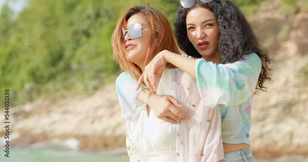 Two female friends are having fun walking on the beach. Lesbian couples spend time together on the beach. Two female friends are having fun walking on the beach. Lesbian couples spend time together on the beach.