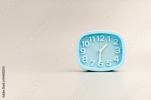 blue alarm clock on gray background time concept