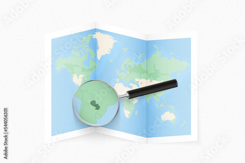 Enlarge Paraguay with a magnifying glass on a folded map of the world.