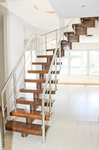 brown wooden staircase in the interior of a duplex apartment