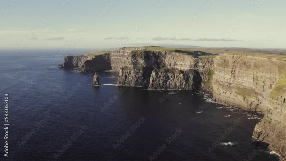 Cinematic aerial of Cliffs of Moher, Ireland during golden hour on sunny day. Flying forward, epic view over ocean with Pinnacle Rock and O'Brien's Tower ocean waves crashing against rocks. 4K Cinematic aerial of Cliffs of Moher, Ireland during golden hour on sunny day. Flying forward, epic view over ocean with Pinnacle Rock and O'Brien's Tower ocean waves crashing against rocks. 4K
