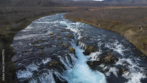 Drone flying over Bruararfoss waterfall and surrounding landscape, Iceland. Aerial forward photo