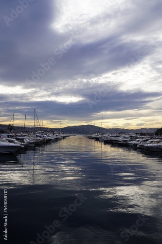 Fototapeta Naklejka Na Ścianę i Meble -  Sailboats at Tarabya yacht marina in Istanbul. Reflection of yachts and hotel. Blue sky and natural white clouds.