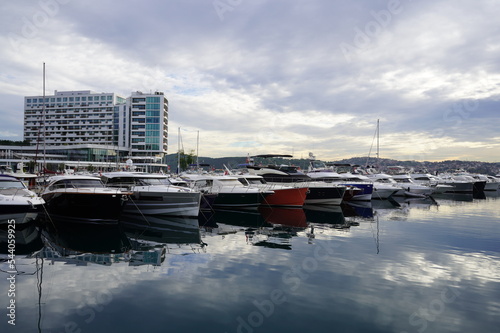 Sailboats at Tarabya yacht marina in Istanbul. Reflection of yachts and hotel. Blue sky and natural white clouds. photo