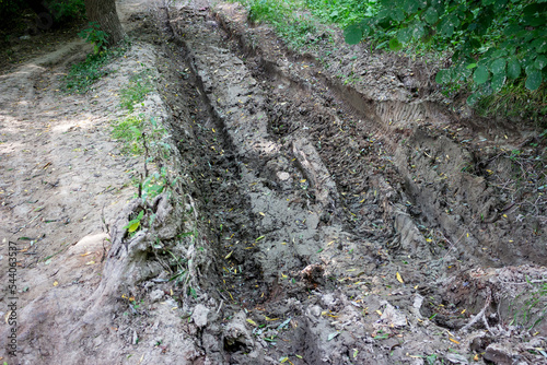 Deep rut dug in a country road by ATV wheels photo