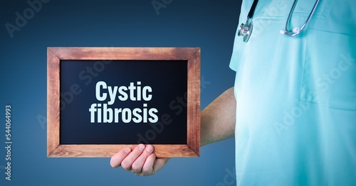 Cystic fibrosis. Doctor shows sign/board with wooden frame. Background blue photo