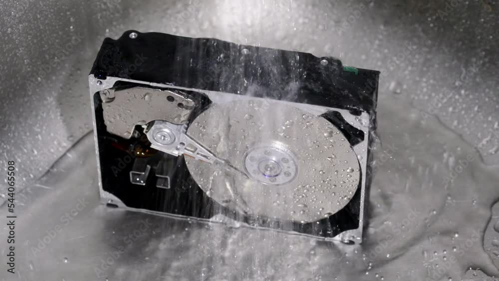 Computer hard drive under running water. Crazy data cleaning idea. Hard Drive under tap water. Concept of Cleaning Hard Drive.