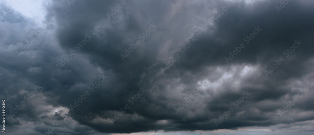 The dark sky with heavy clouds converging and a violent storm before the rain.Bad or moody weather sky and environment. carbon dioxide emissions, greenhouse effect, global warming, climate change