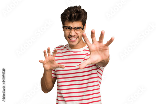 Young caucasian handsome man isolated showing claws imitating a cat, aggressive gesture.