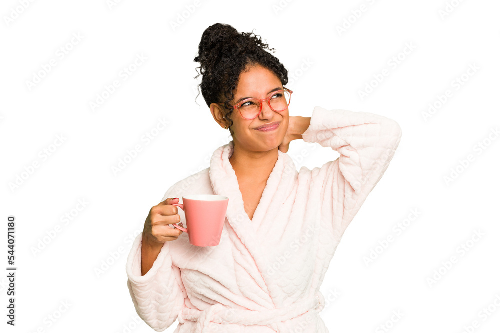 Young brazilian woman wearing a pajama holding a cup isolated touching back of head, thinking and making a choice. Young brazilian woman wearing a pajama holding a cup isolated touching back of head, thinking and making a choice.