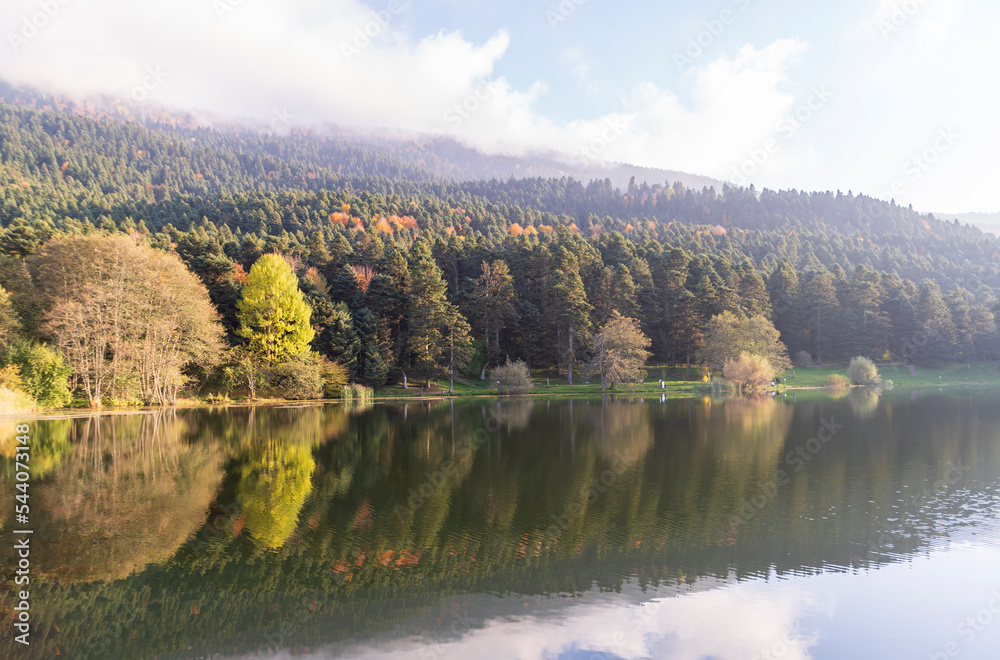 Wooden Lake house inside forest in Bolu Golcuk National Park, Bolu, Turkey. Reflection of autumn trees