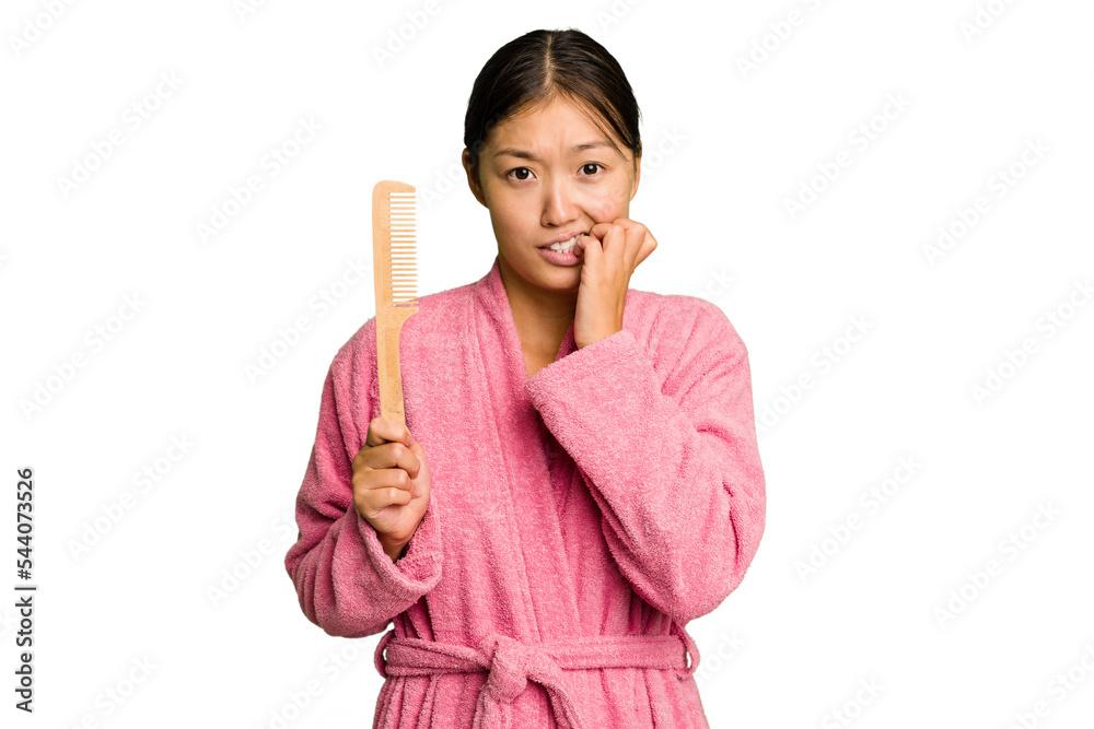 Young asian woman holding an hair comb isolated biting fingernails, nervous and very anxious. Young asian woman holding an hair comb isolated biting fingernails, nervous and very anxious.