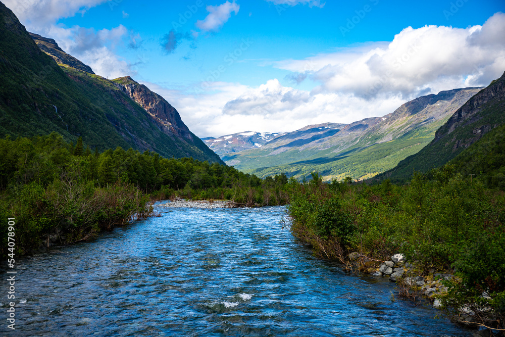 a rushing river flowing through the mountains in northern norway, lyngenfjord; the rugged landscape of the norwegian fjords