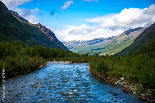 Fototapeta Naklejka Na Ścianę i Meble -  a rushing river flowing through the mountains in northern norway, lyngenfjord; the rugged landscape of the norwegian fjords