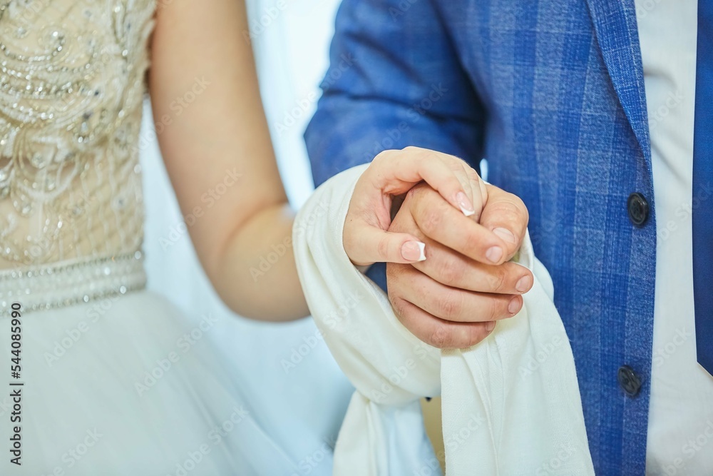 The hands of the bride and groom. Wedding ceremony or engagement celebration.