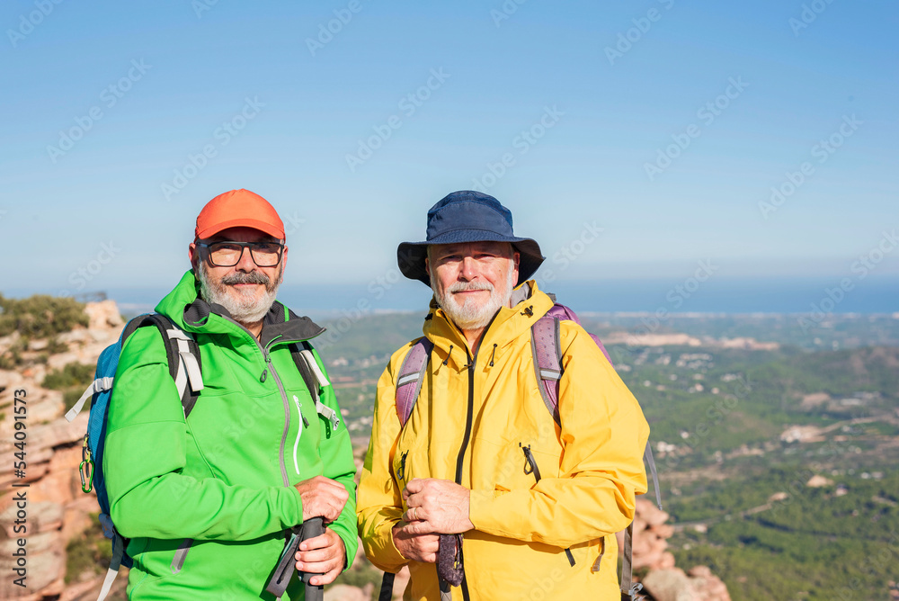 two elderly men hiking in the mountains. Active retirement concept