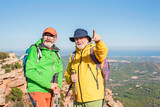 two male mature hikers at the top of mountain. People adventure and active retirement concept