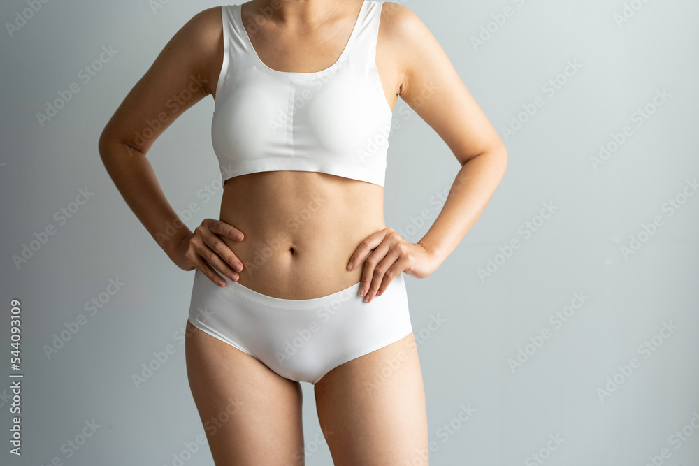 Cropped image of sexy attractive young woman in white underwear showing fit body standing posing hold hand on hips legs isolated on white wall background studio portrait Cropped image of sexy attractive young woman in white underwear showing fit body standing posing hold hand on hips legs isolated on white wall background studio portrait