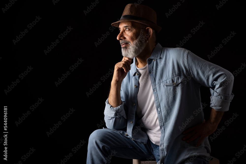 Portrait of senior man with hunter hat against dark background Portrait of senior man with hunter hat against dark background