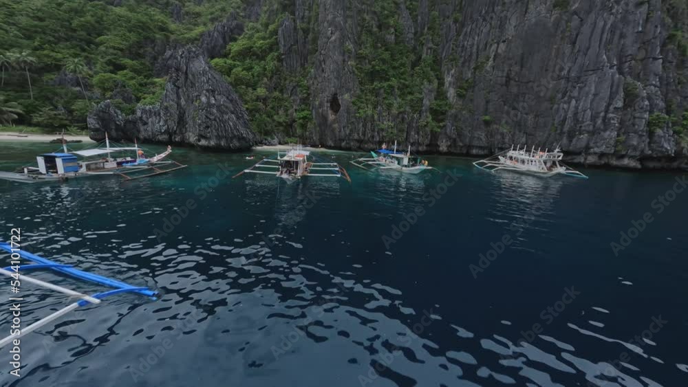 Ripple sea water surface paradise Asian island bay with water transport boat and tourist people aerial view. FPV sports drone shot picturesque seaside lagoon tropical mountain cliff sand beach scenery Ripple sea water surface paradise Asian island bay with water transport boat and tourist people aerial view. FPV sports drone shot picturesque seaside lagoon tropical mountain cliff sand beach scenery