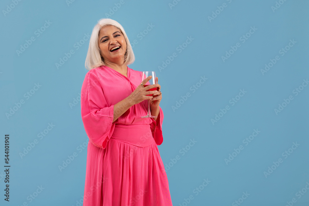 Portrait of a cheerful old lady standing with a glass of red wine Portrait of a cheerful old lady standing with a glass of red wine