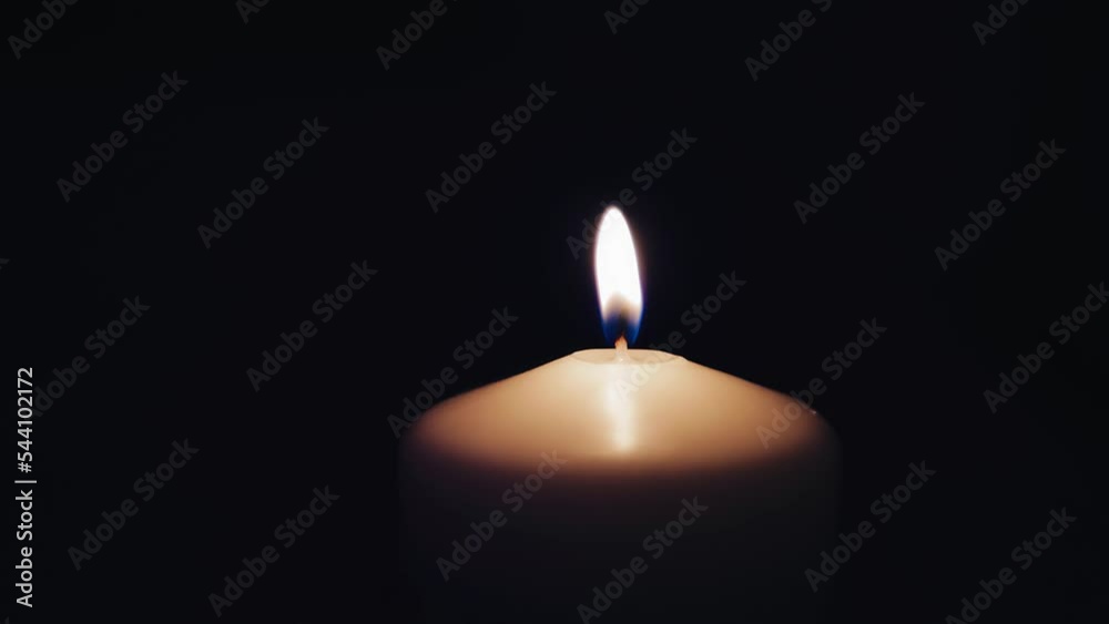 The candle burns in a completely dark room. The camera shoots close-up in slow motion The candle burns in a completely dark room. The camera shoots close-up in slow motion