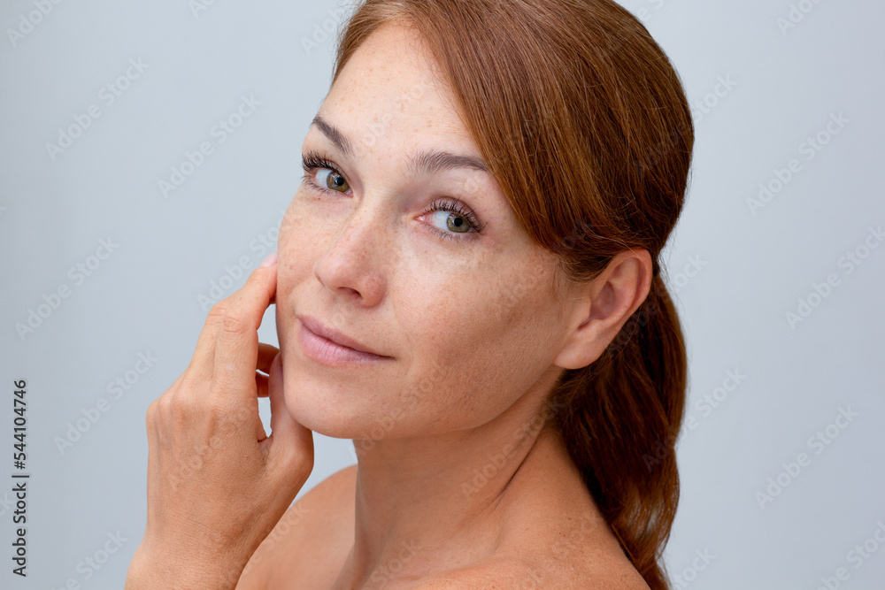 Portrait of smiling middle aged woman looking at camera holding hands on face on white background Portrait of smiling middle aged woman looking at camera holding hands on face on white background