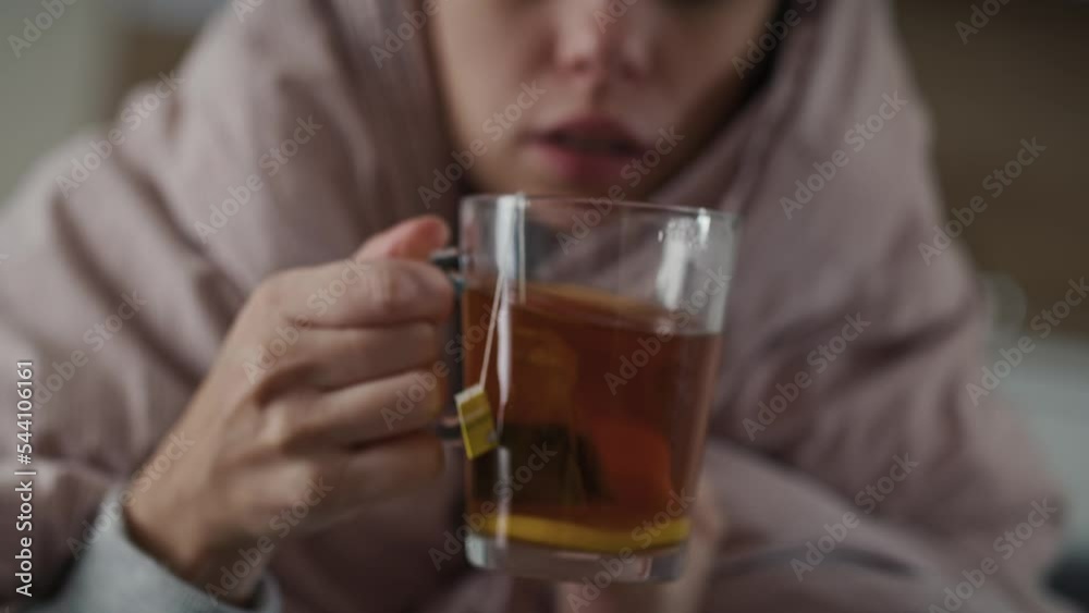 Caucasian woman sitting under the duvet with tea at home. Shot with RED helium camera in 8K. Caucasian woman sitting under the duvet with tea at home. Shot with RED helium camera in 8K.