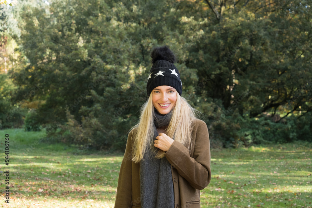 Close up of a woman walking in a forest in wooly hat and coat
