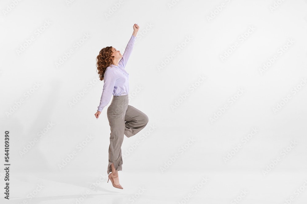 Portrait of young woman reaching top isolated over white studio background. Growing professional ambitions