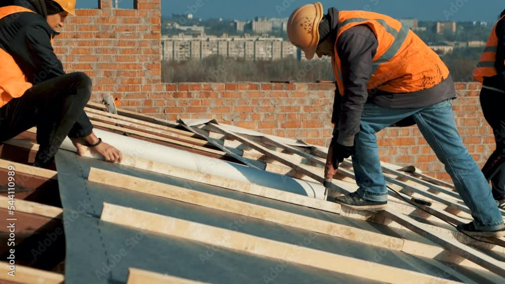 Construction worker wearing safety harness belt during working on roof
