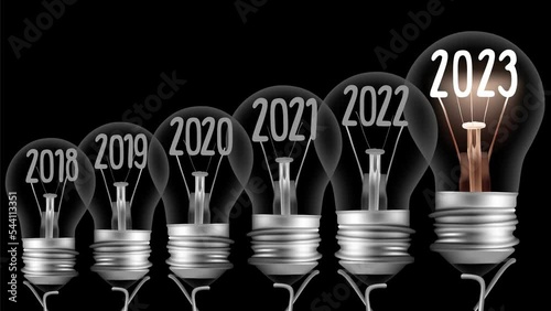 Shining light bulb with New Year 2023 and group of dark light bulbs in a row going from 2015 to 2022 isolated on black background. High quality 4k video.