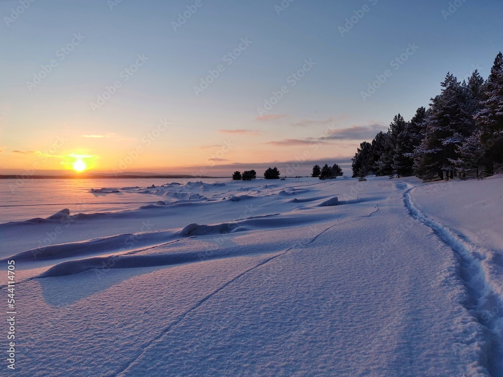 Winter sunset on frozen White sea, gulf of Kandalaksha, Kola Peninsula. Beautiful arctic landscape. 