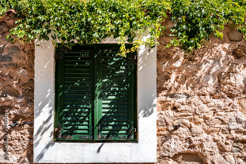 Fenêtre avec volets clos et mur ensoleillé à Pag en Croatie