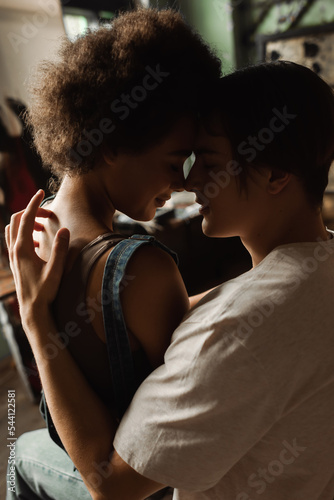 curly african american woman with young artist sitting face to face with closed eyes in workshop.