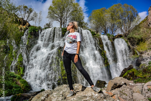 A young girl near the Shaki waterfall, with a height of 18 m. It is located in the Syunik region of Armenia, near the city of Goris. May 5, 2019