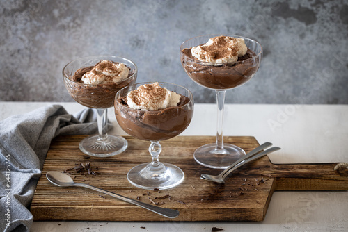Three glasses of chocolate mousse with whipped cream photo