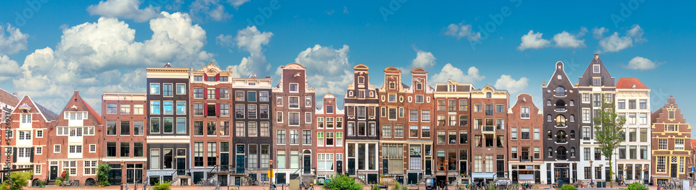 Amsterdam Long Panorama of famous Amsterdam houses with blue sky. Various traditional houses in the historic center of Amsterdam. Amsterdam, Holland, Netherlands,