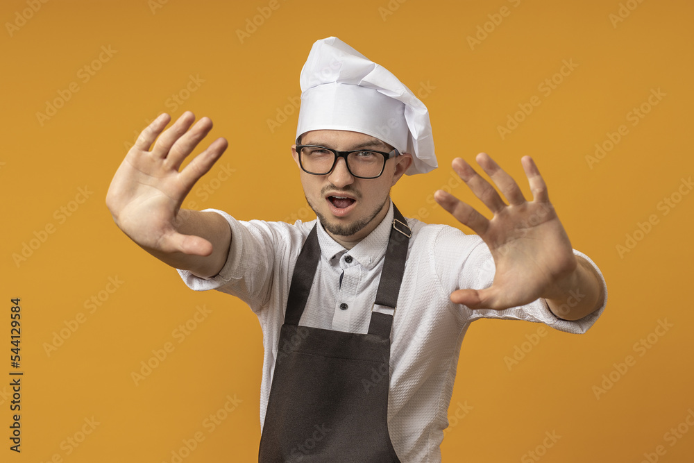 the cook extended both palms forward, urging them to stop. concept do not enter. the cook extended both palms forward, urging them to stop. concept do not enter.