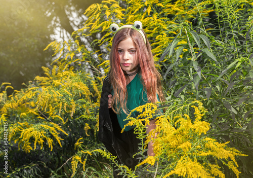 Teenage girl in goldenrod flowers. Selective focus. Blurred background.