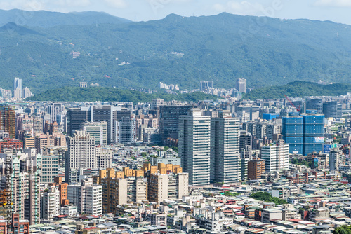 Overlooking view of the modern urban landscape of the Taipei area in Taiwan. It's a basin terrain surrounded by mountains. photo