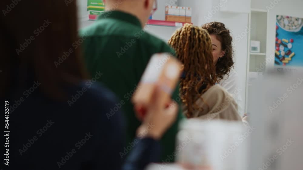 Medical employee serving clients with pills and medicaments, scanning medicine products and giving assistance in pharmacy. Pharmacist helping people to buy treatment and drugs. Handheld shot.