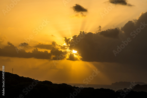 Mystical sun rays from a dramatic cloudy sunrise sky.