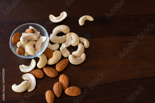Cashewnuts and almonds arranged on a table in small bowl of glass. Kaju, badam, dry fruits, healthy, cholesterol, sweet, tasty, Diwali, festival, gift, shopping, box, soak, nuts, protein, fats, carbs. photo