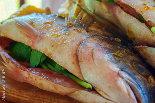 Dorado fish with lemon and spices prepared for grill.