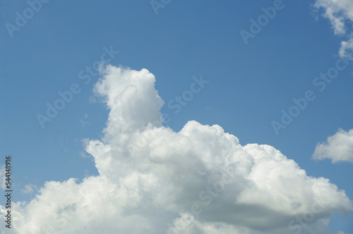 A white cloud in the shape of a man against a blue sky. Created by nature.